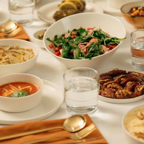 An inviting iftar table setting with various Middle Eastern dishes and cutlery.
