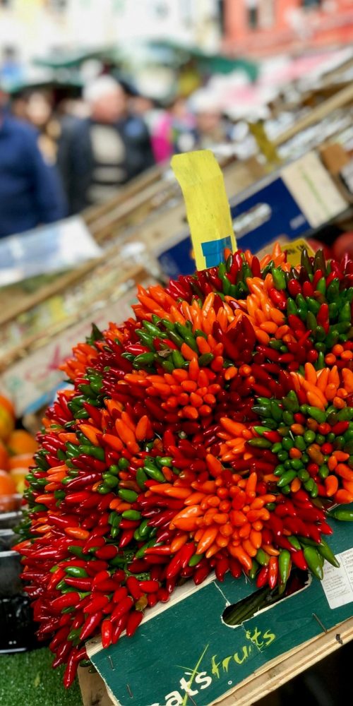 Vibrant produce display at a bustling market in Venice, Italy.